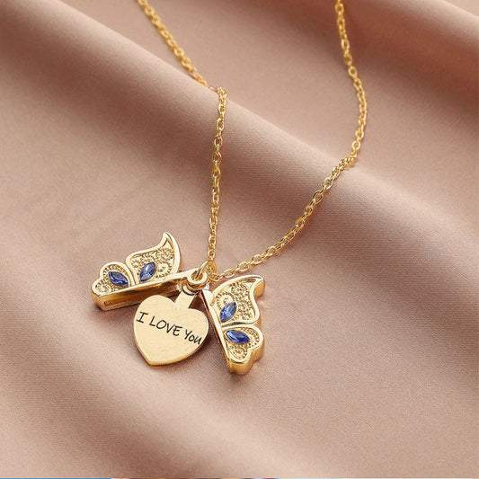 Gold necklace with heart-shaped 'I LOVE YOU' pendant on a beige fabric background