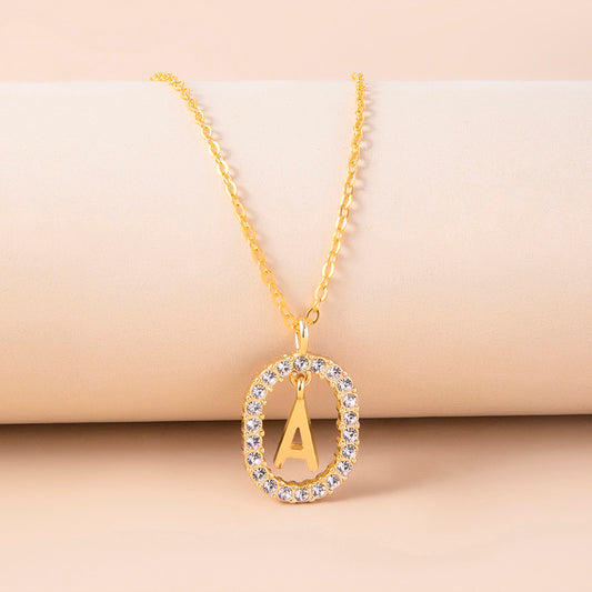 Gold necklace with a pendant featuring the letter 'A' on a beige background