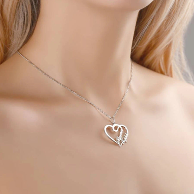 Silver heart-shaped necklace with engraved text on a person's neck