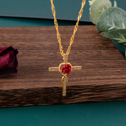 Gold necklace with a red rose pendant on a wooden surface
