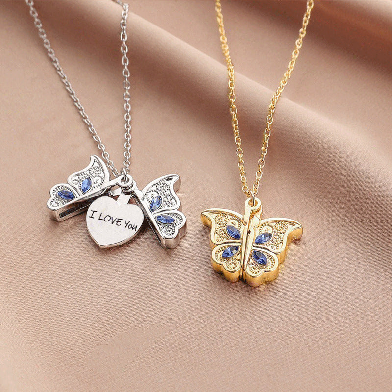 Butterfly-shaped necklaces with 'I LOVE YOU' heart pendant on a beige fabric background